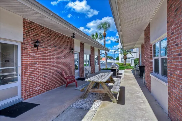 a view of a building next to a big yard and large trees