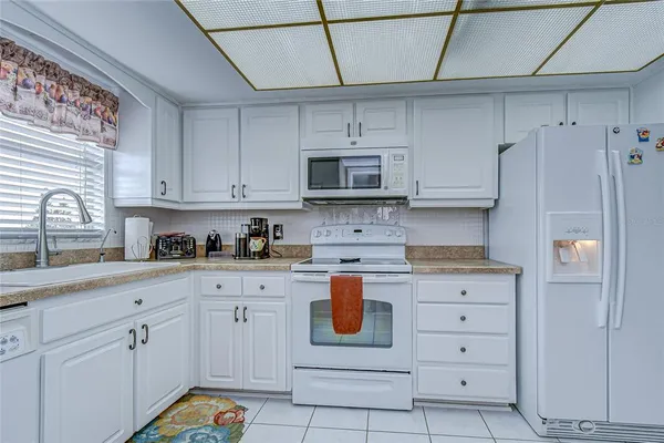 a kitchen with stainless steel appliances white cabinets and a refrigerator
