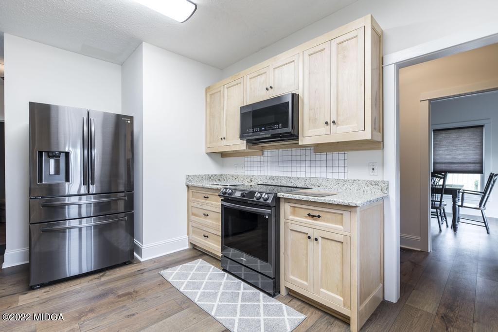 911 Lassiter Road Forsyth, GA 31029 - Photo 28 of 55 a kitchen with cabinets stainless steel appliances and wooden floor