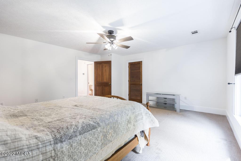 911 Lassiter Road Forsyth, GA 31029 - Photo 44 of 55 a bedroom with a bed and a chandelier