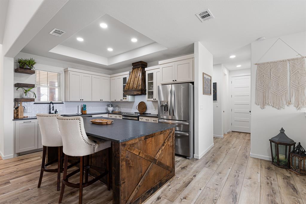 476 Silverleaf Drive Sunset, TX 76270 - Photo 11 of 40 a kitchen with refrigerator cabinets dining table and chairs