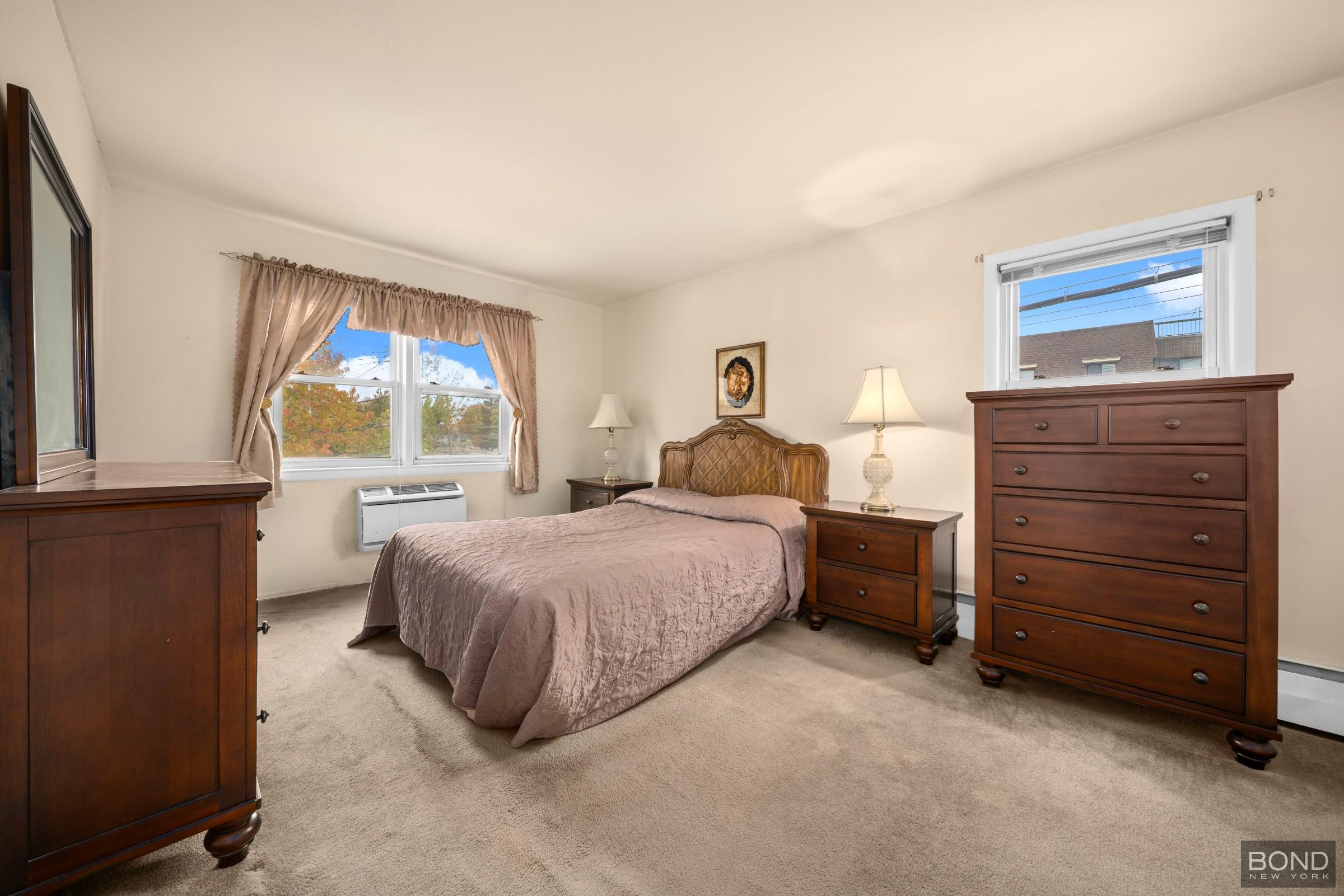 69-01 61st Road Queens, NY 11379 - Photo 5 of 9 a bedroom with a bed and a window