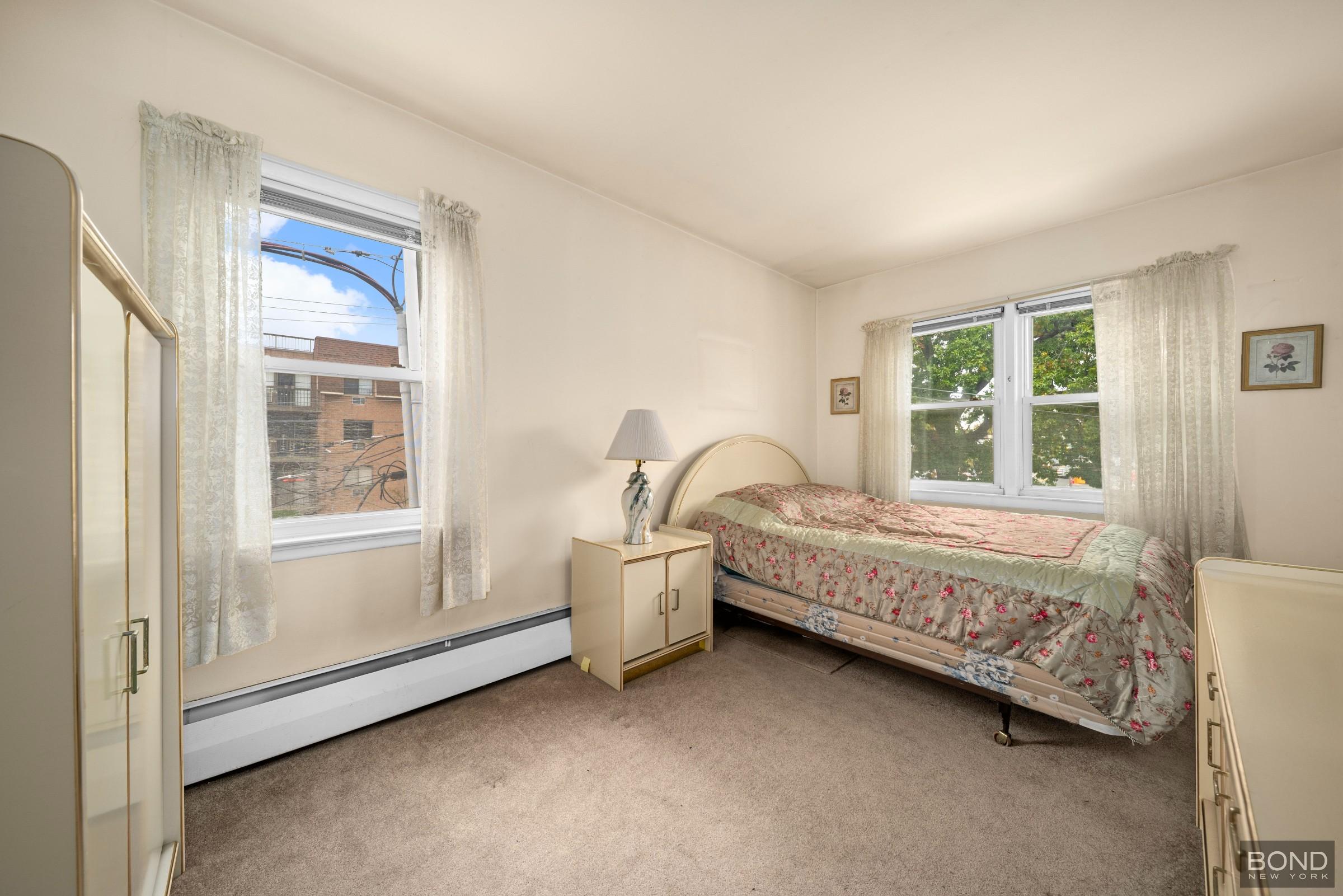 69-01 61st Road Queens, NY 11379 - Photo 6 of 9 a bed sitting in a room next to a window