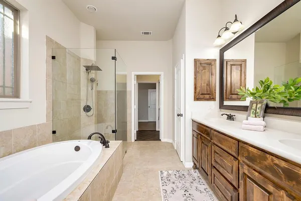 a bathroom with a tub sink and mirror