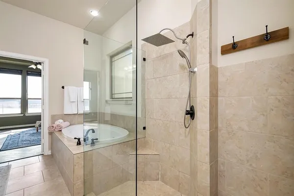 a bathroom with a tub a sink and a large mirror