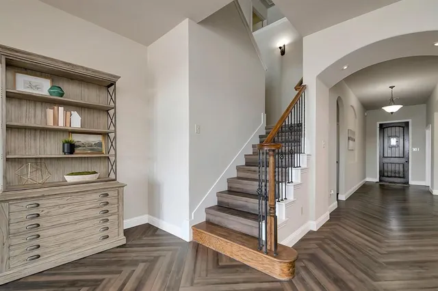 a view of a hallway with wooden floor and staircase