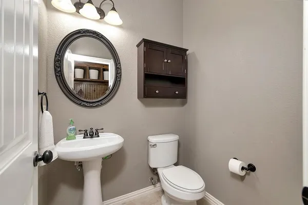a bathroom with a toilet sink and mirror
