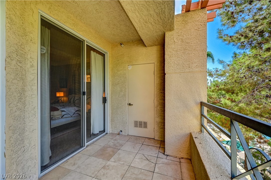 230 East Flamingo Road, Unit 333 Las Vegas, NV 89169 - Photo 35 of 61 Tiled private balcony with sliding glass door entry overlooks mature trees.