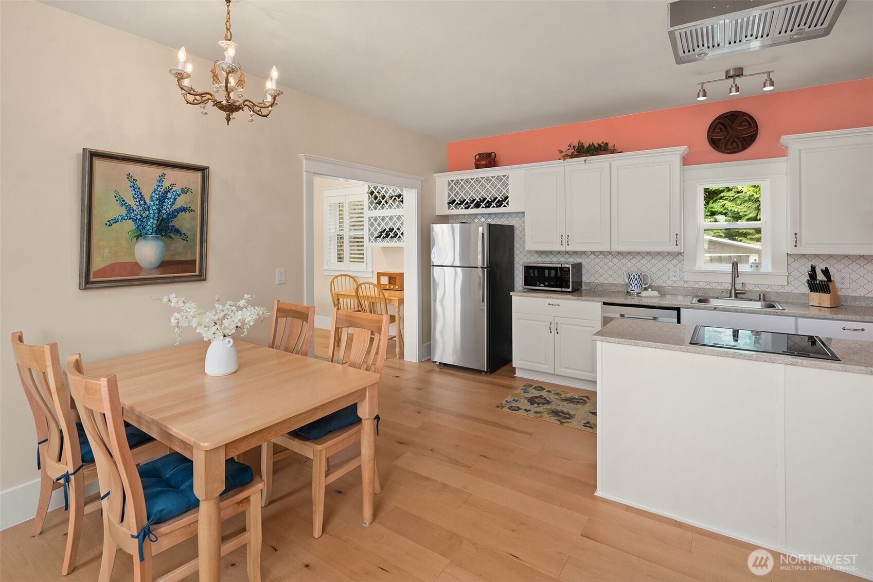 6007 Southwest 240th Street Vashon, WA 98070 - Photo 24 of 40 a kitchen with a refrigerator a stove a dining table and chairs with wooden floor