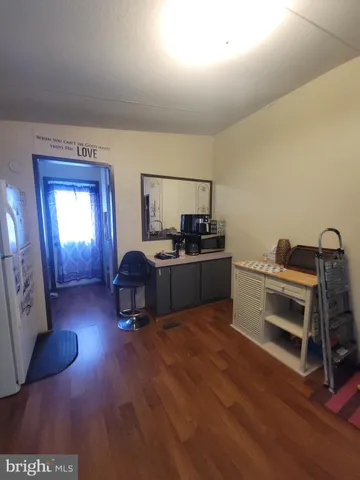 a living room with a piano and wooden floor