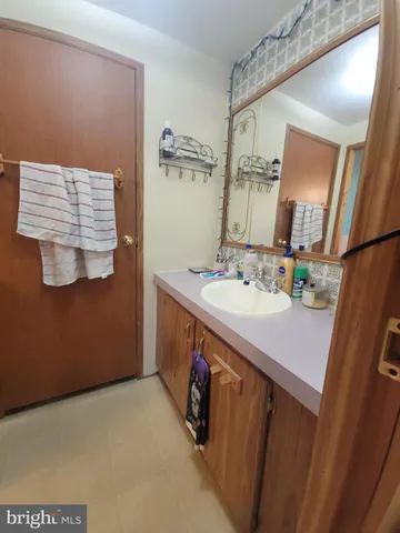 a bathroom with a sink vanity and mirror