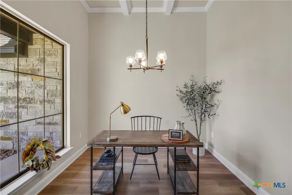 a view of a dining room with furniture a chandelier and wooden floor