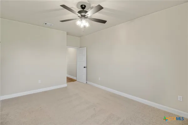 an empty room with a chandelier fan