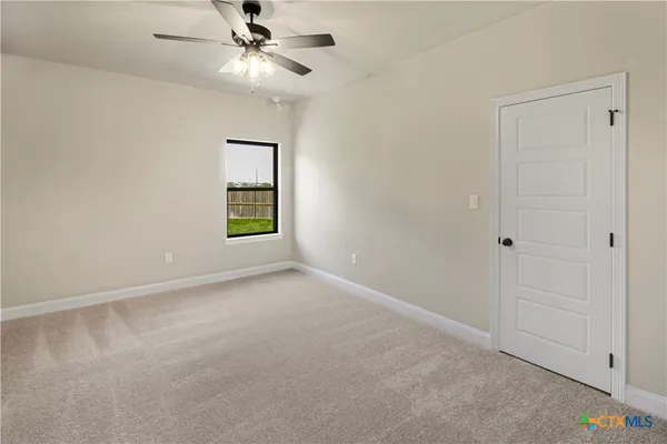 an empty room with windows and fan
