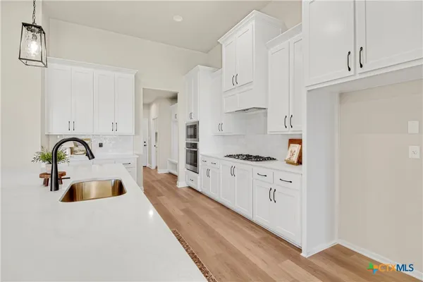 a large white kitchen with stainless steel appliances