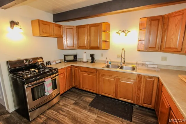 a kitchen with stainless steel appliances a sink a stove and cabinets