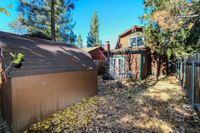 a view of a yard with wooden fence