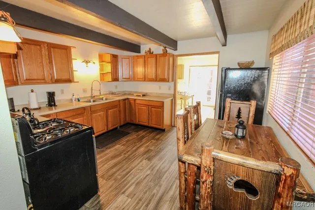 a kitchen with granite countertop a stove a sink dishwasher and a refrigerator