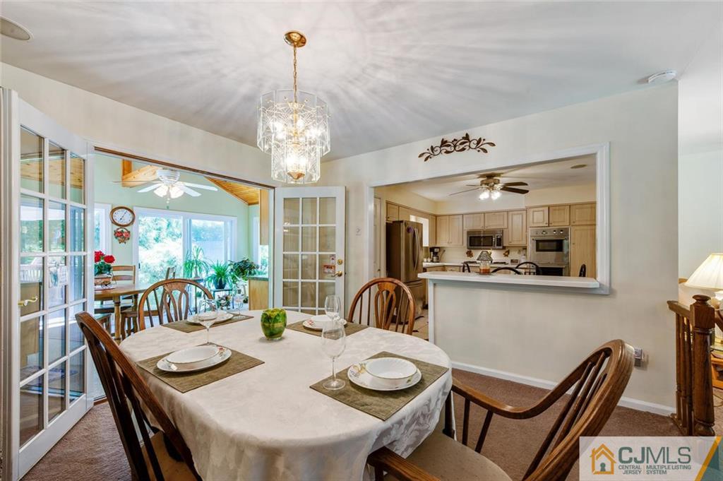 304 Fresh Ponds Road North Brunswick, NJ 08902 - Photo 12 of 44 a view of a dining room with furniture a chandelier and wooden floor