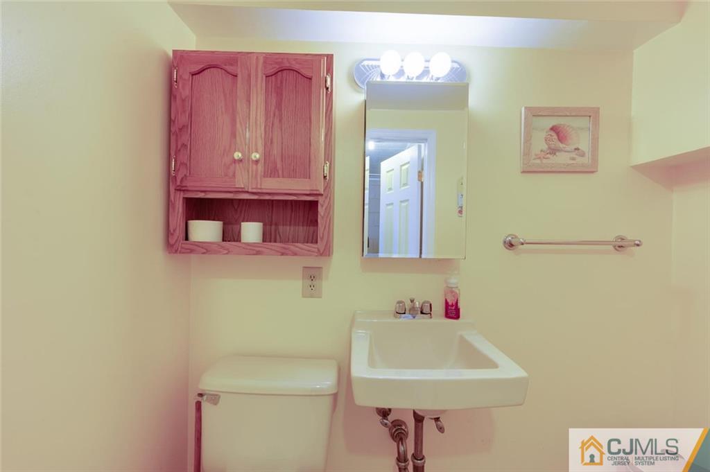 304 Fresh Ponds Road North Brunswick, NJ 08902 - Photo 24 of 44 a bathroom with a sink a toilet and a mirror