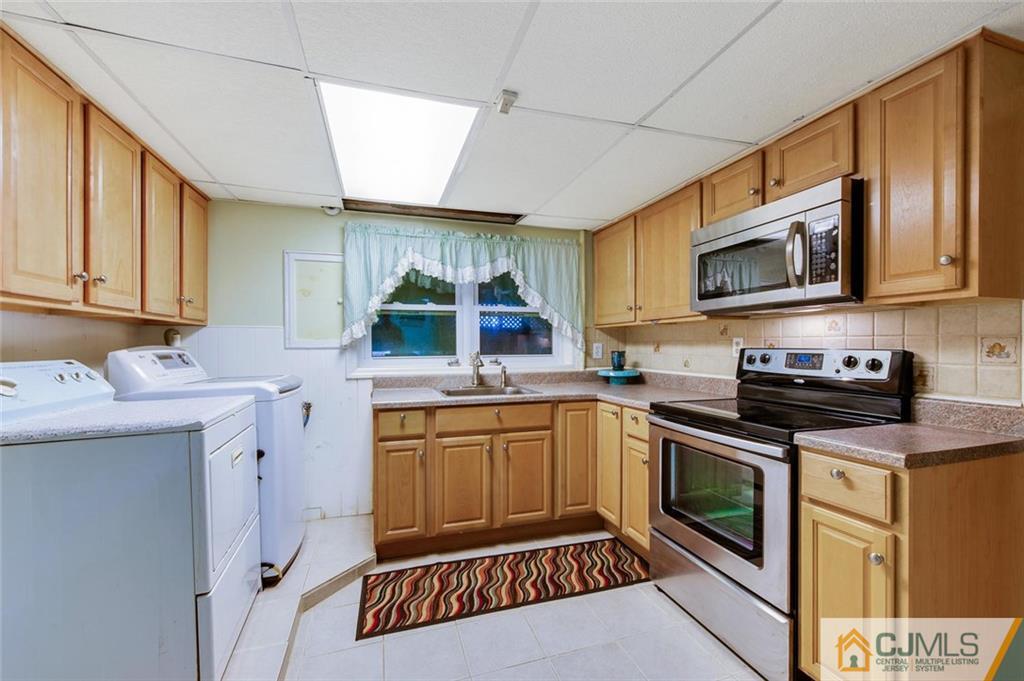 304 Fresh Ponds Road North Brunswick, NJ 08902 - Photo 26 of 44 a kitchen with stainless steel appliances a stove sink microwave and cabinets