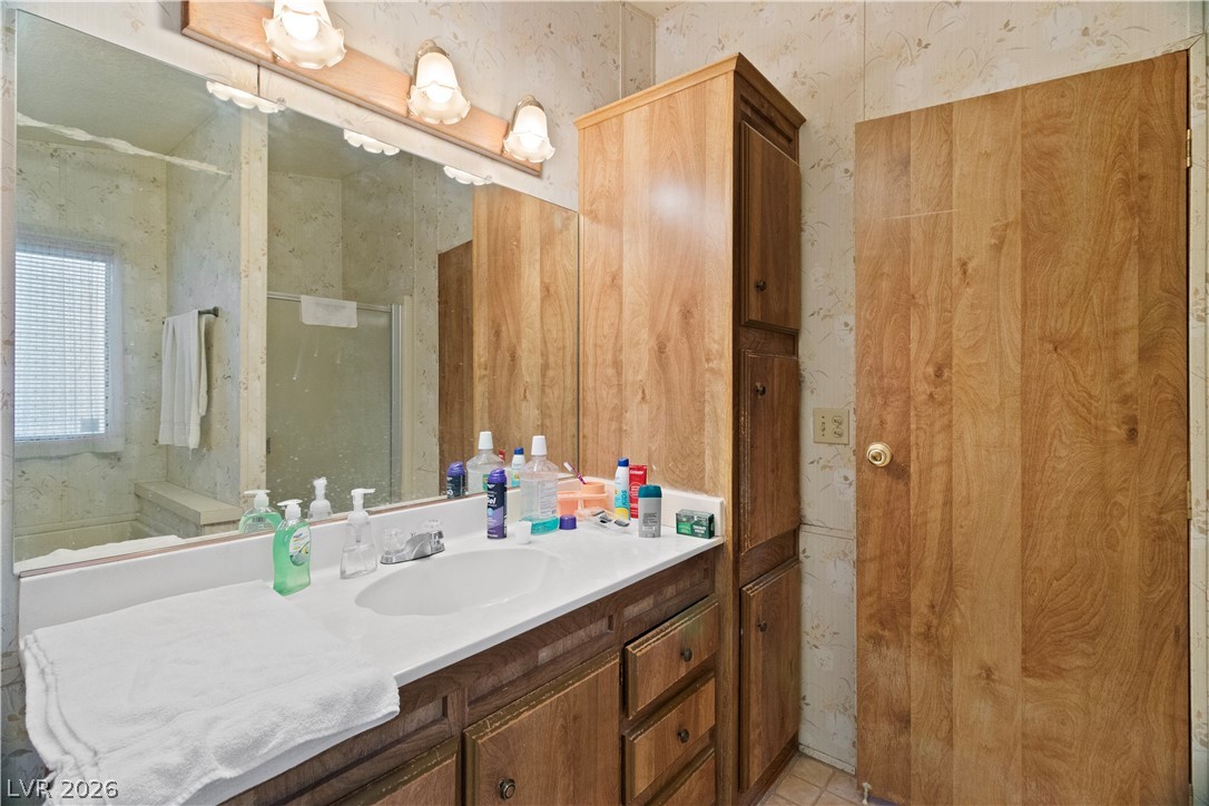 1609 Cajon Court Laughlin, NV 89029 - Photo 24 of 69 Full Primary ensuite bathroom featuring a stall shower, vanity, and wallpapered walls