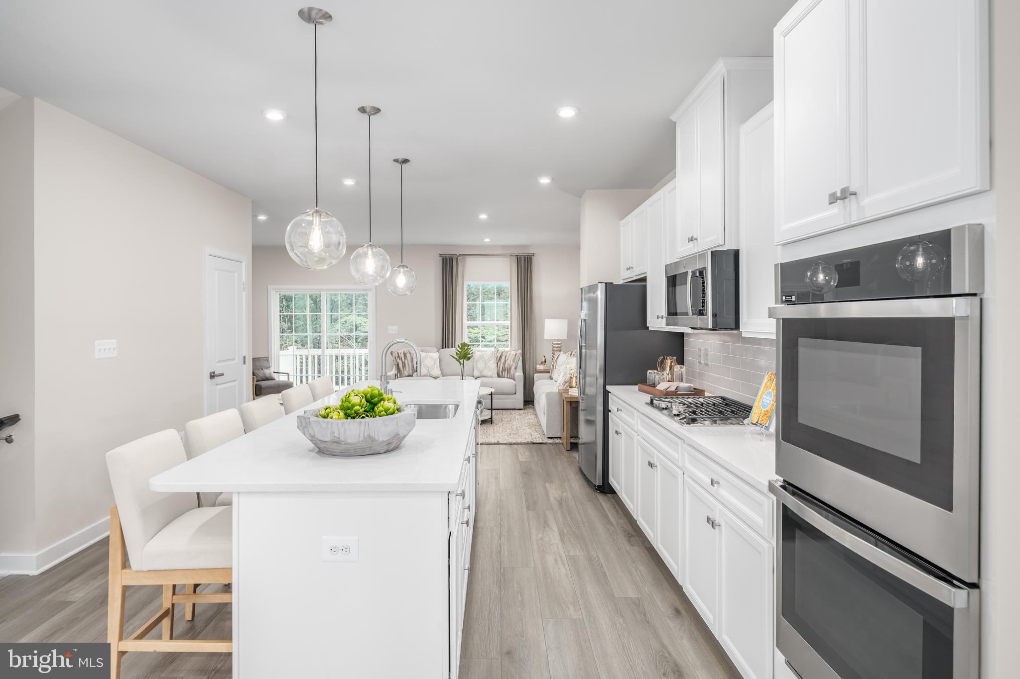 8428 Branch Side Way, Unit D Brandywine, MD 20613 - Photo 8 of 23 a kitchen with stainless steel appliances kitchen island granite countertop a sink a stove and a wooden floors