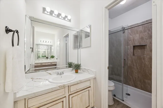a bathroom with a sink a toilet and shower