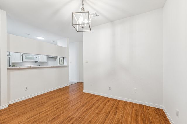 a view of a kitchen with wooden floor and cabinets