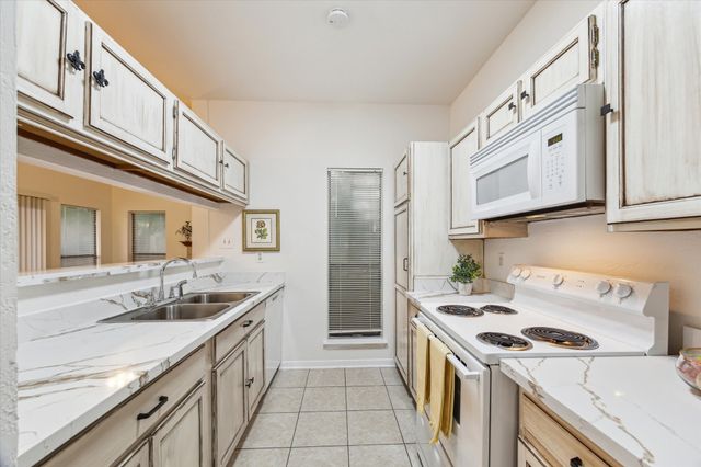 a kitchen with a sink stove top oven and cabinets
