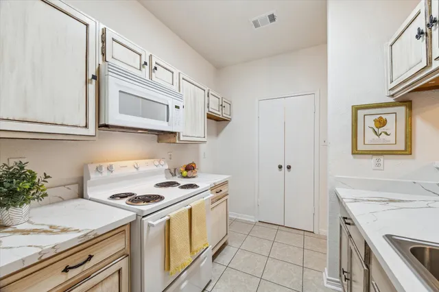 a kitchen with stainless steel appliances granite countertop a white stove top oven a sink and dishwasher