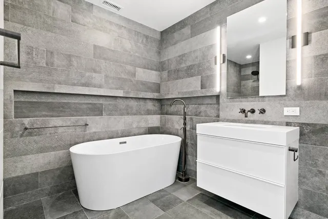 a white bath tub sitting in a bathroom and sink