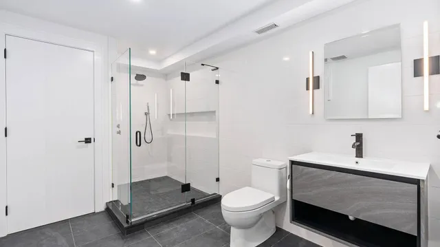 a bathroom with a sink a toilet and shower