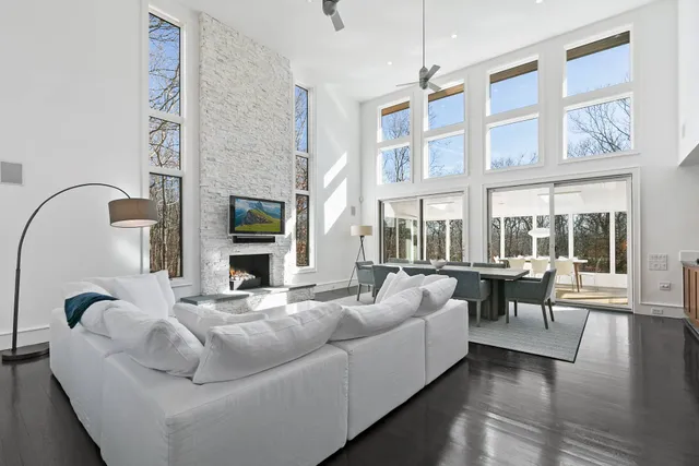 a living room with fireplace furniture and a large window