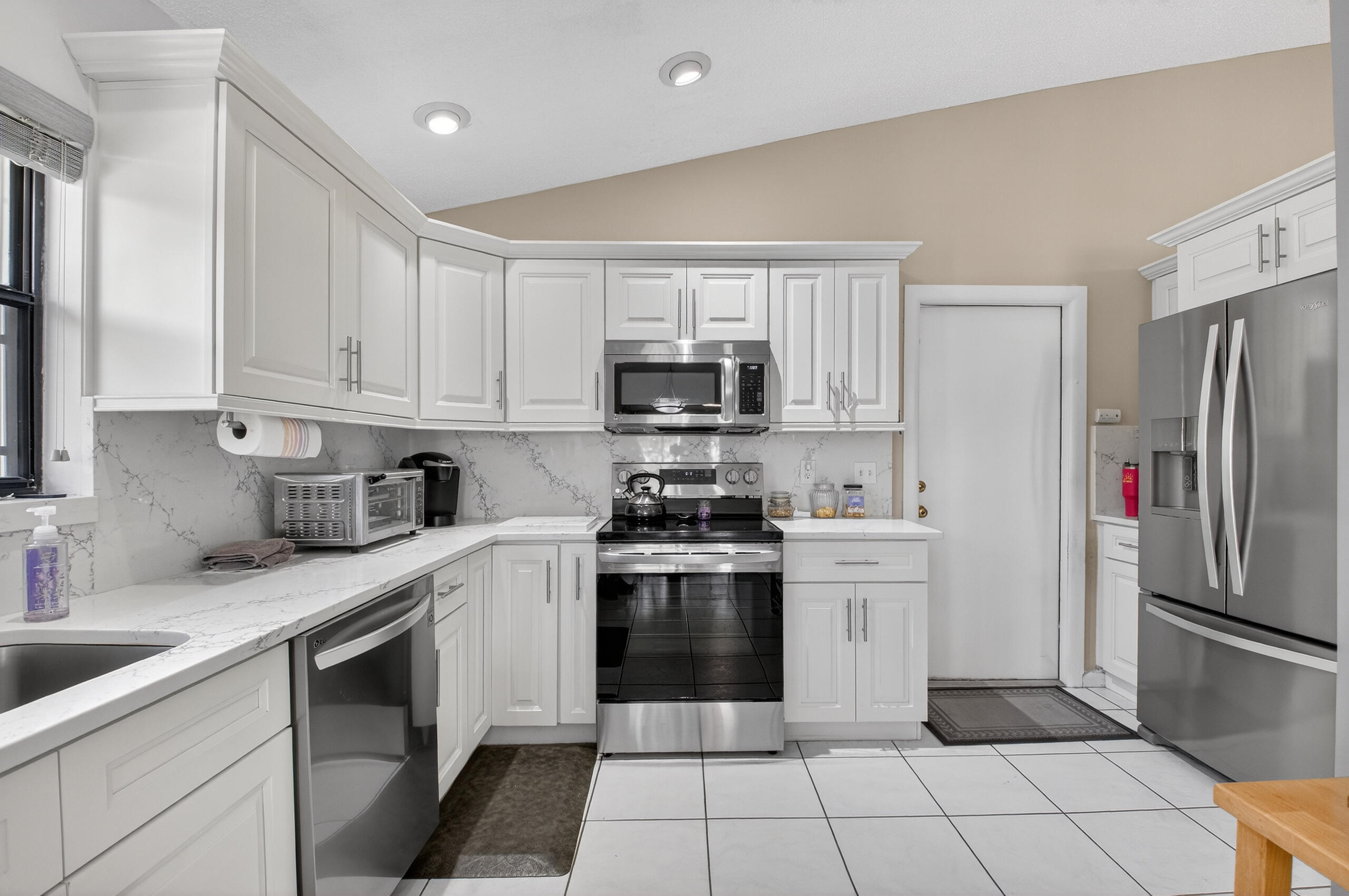 2601 Northwest 15th Street Delray Beach, FL 33445 - Photo 18 of 59 a kitchen with stainless steel appliances granite countertop a stove a sink and a refrigerator