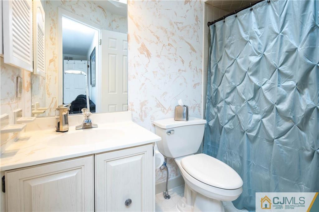 205 Timber Oaks Road, Unit 205 Edison, NJ 08820 - Photo 25 of 31 a bathroom with a granite countertop toilet sink and mirror