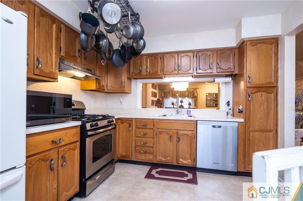 205 Timber Oaks Road, Unit 205 Edison, NJ 08820 - Photo 6 of 31 a kitchen with stainless steel appliances granite countertop a stove a sink and dishwasher cabinets with wooden floor