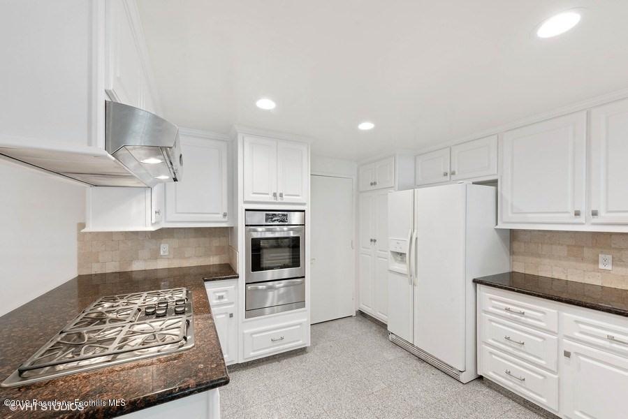 421 Cloverleaf Drive Monrovia, CA 91016 - Photo 7 of 21 a kitchen with stainless steel appliances kitchen island granite countertop a refrigerator stove oven and white cabinets