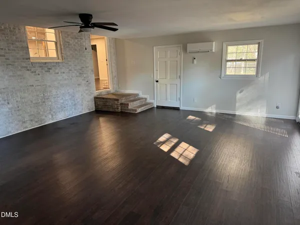 a view of a livingroom with wooden floor and a window