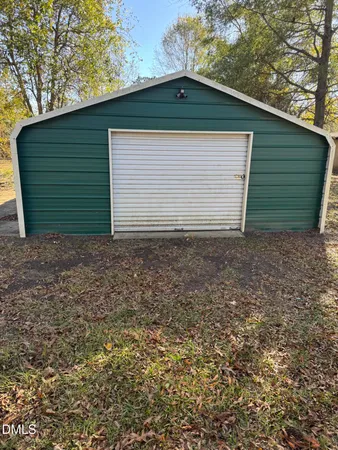 a small white house with a yard and garage