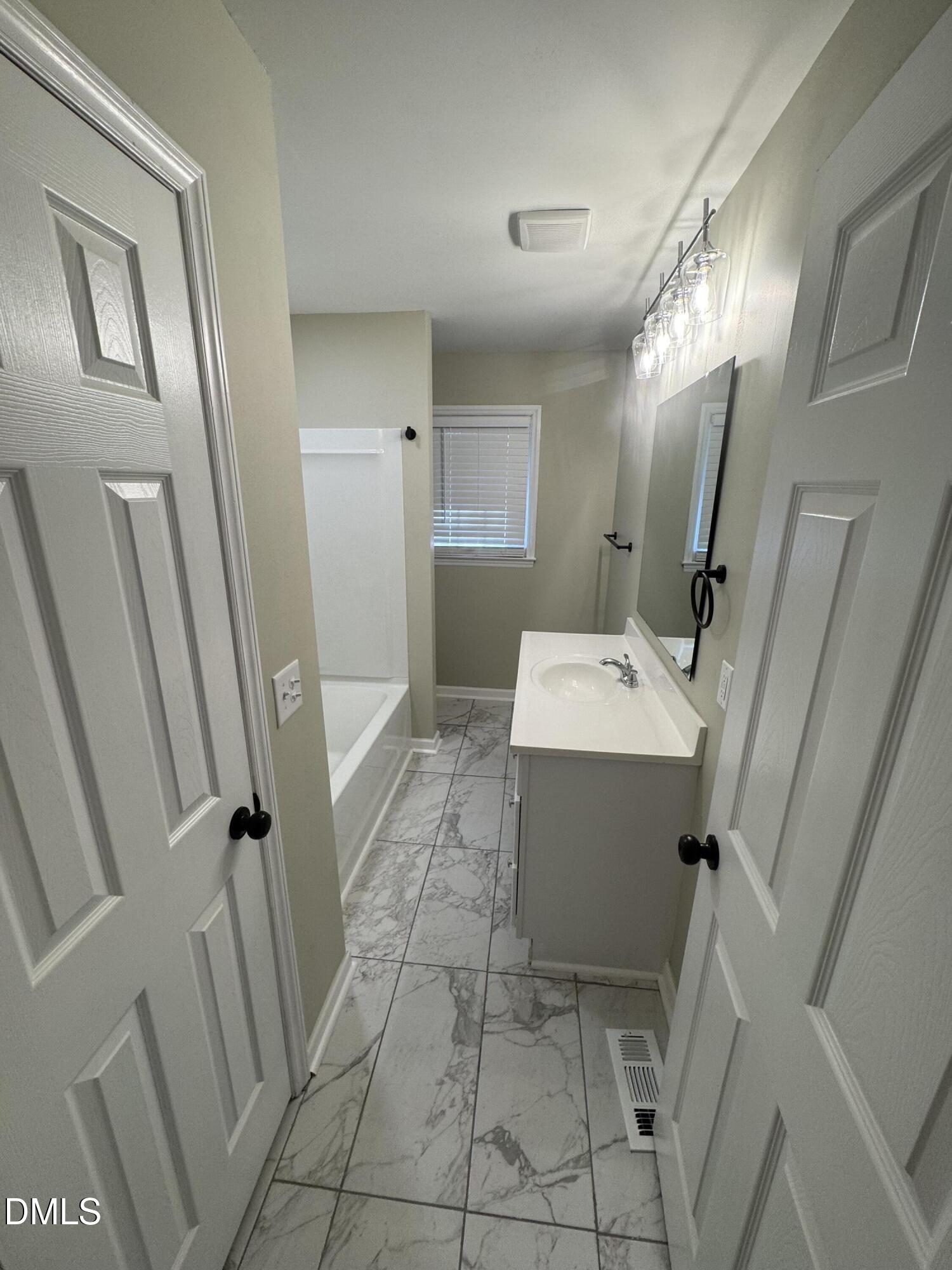 11993 Rockside Road Middlesex, NC 27557 - Photo 8 of 15 a bathroom with a sink a mirror and a shower