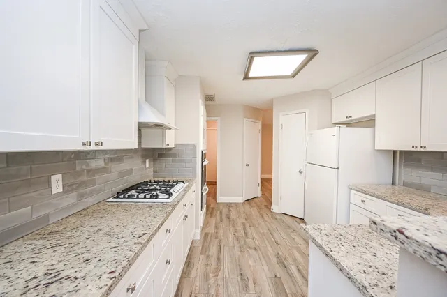 a kitchen with stainless steel appliances granite countertop a stove and a refrigerator