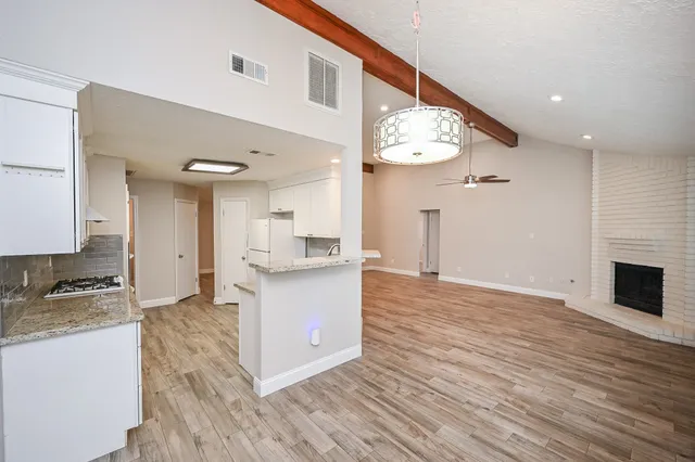 a kitchen with granite countertop a sink stove and cabinets
