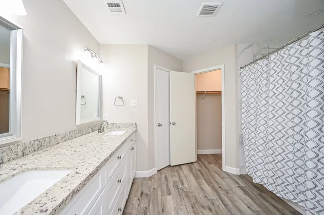 a bathroom with a granite countertop sink and a mirror