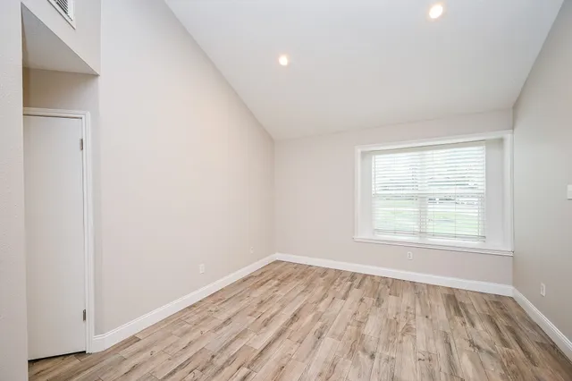 a view of empty room with wooden floor and fireplace