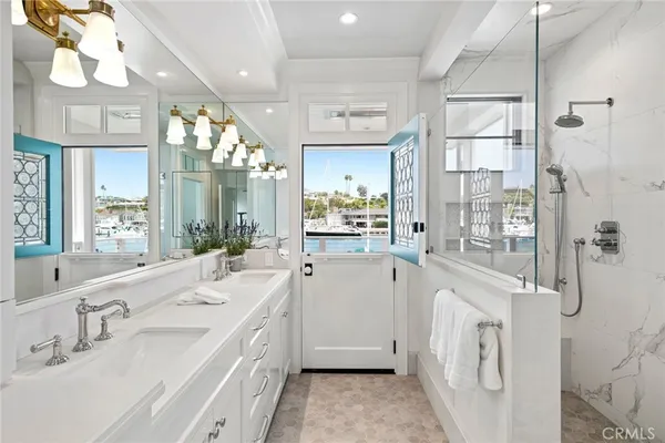 a spacious bathroom with a double vanity sink a mirror and shower