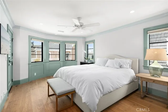 a bedroom with a bed wooden floor and window