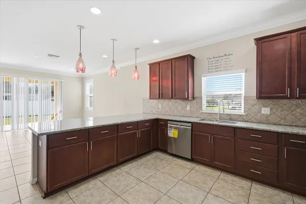 a kitchen with stainless steel appliances granite countertop a sink refrigerator and cabinets