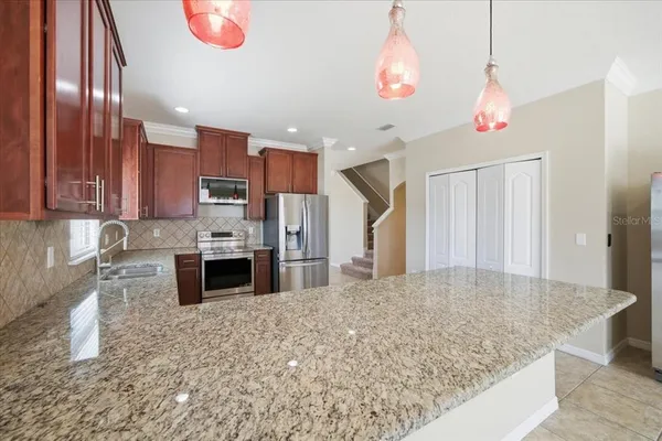 a kitchen with granite countertop cabinets stainless steel appliances a sink and a window