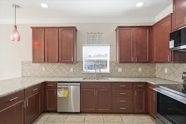 a kitchen with stainless steel appliances granite countertop a refrigerator and a stove top oven